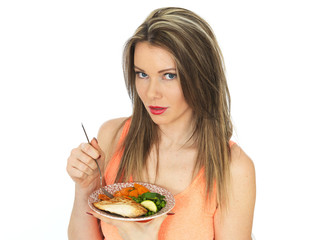 Young Woman Eating Grilled Chicken with Vegetables