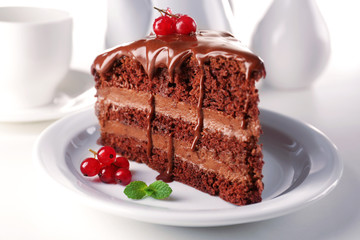 Delicious chocolate cake on plate on table on light background