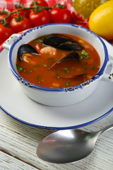 Tasty soup with shrimps, mussels, tomatoes and black olives in
