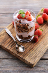 Healthy layered dessert with muesli and berries on table