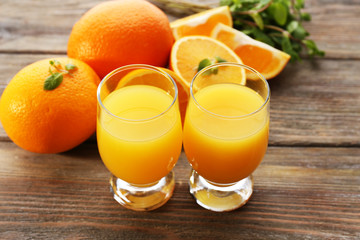 Glass of orange juice and slices on wooden table background