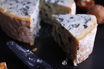 Blue cheese with nuts and blade on metal tray background