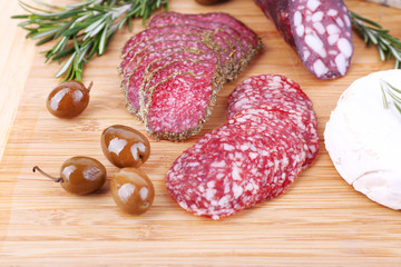 Smoked sausages with cheese, olives and sprigs of rosemary