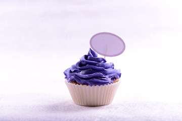Delicious cupcake with inscription on table on beige background