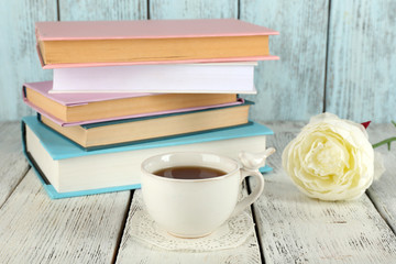 Cup of tea with books on wooden background