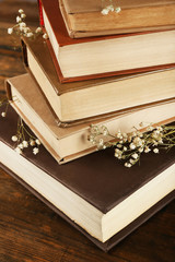 Books with dried flowers on wooden background