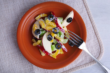 Waldorf salad with olive on plate on table close up