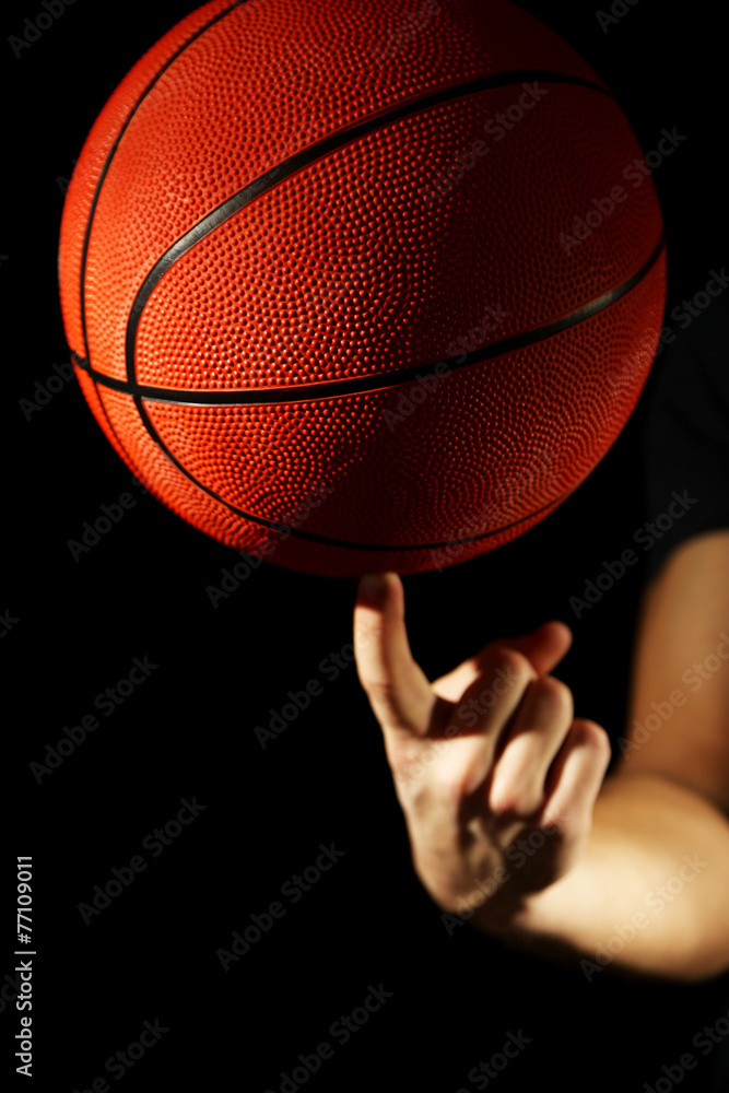 Wall mural Basketball player holding ball, on dark background