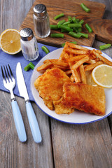 Breaded fried fish fillets and potatoes with asparagus and