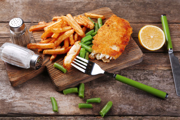 Breaded fried fish fillet and potatoes with asparagus