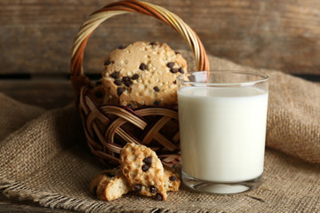 Tasty cookies and glass of milk on rustic wooden background