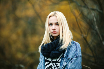 Young serious blonde woman in scarf and jeans jacket