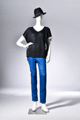 female black clothing in jeans with black hat on mannequin