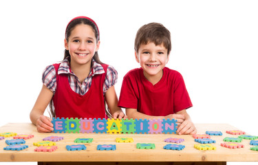 Fototapeta premium Two kids at the table with puzzle letters