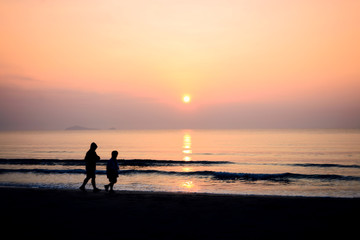 Fototapeta na wymiar silhouette of couple running on the beach