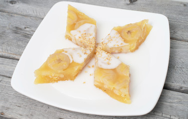 Vietnamese steamed banana cake dipped in coconut milk and sesame