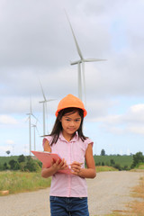 Girl engineer or architect with white safety hat and wind turbin