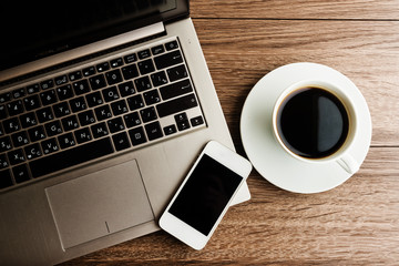 open laptop with phone and cup of coffee