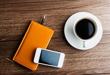 organizer with cup of coffee and mobile phone on desk