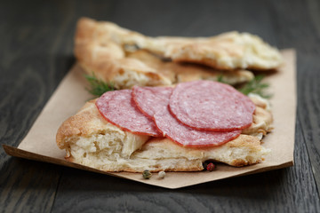 sandwich with pita bread and salami on wood table