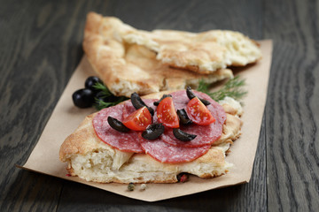 sandwich with pita bread salami and vegetables on wood table