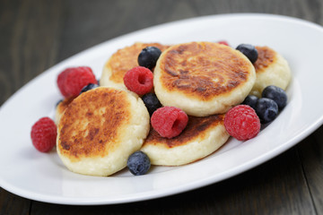 homemade curd fritters on plate with berries