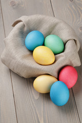 painted easter eggs in basket on wood table