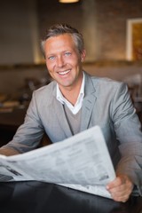 Handsome businessman reading the newspaper