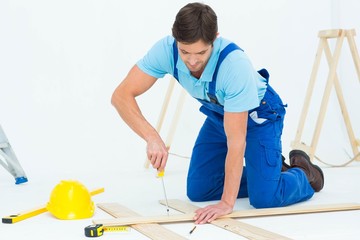 Repairman fixing screw on plank
