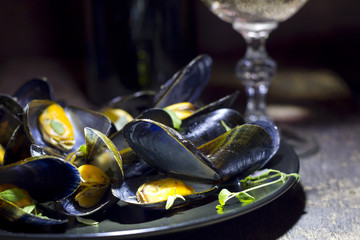 Mussels with glass of white wine and thyme in the dark