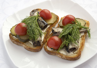 Sandwiches with sprats ,cucumbers and tomatoes