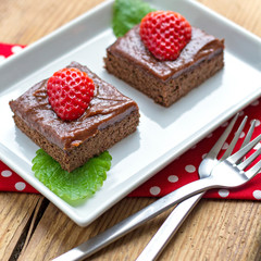 Two pieces of chocolate cake topped with strawberry
