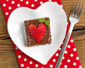 Creamy chocolate cake on heart shaped plate