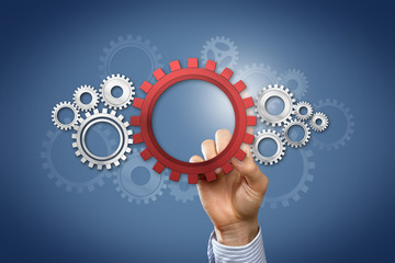 Hand touching cogwheels