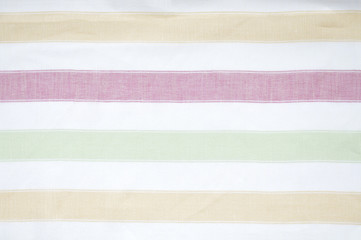 Closeup detail of yellow, red, green and white striped fabric
