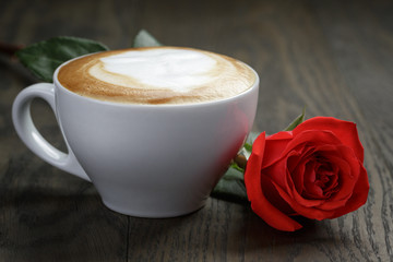 fresh cappuccino with red rose on wood table