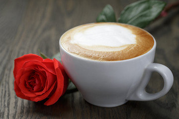 fresh cappuccino with red rose on wood table