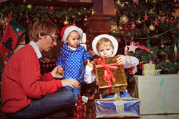 Fototapeta na wymiar father and kids with presents in christmas