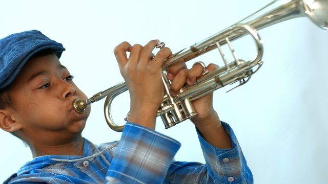 African boy blowing cheeks playing the trumpet