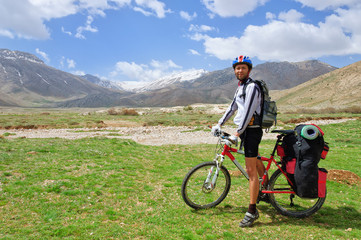 Fototapeta premium Cyclist with a large backpack standing on the Turkish mountains