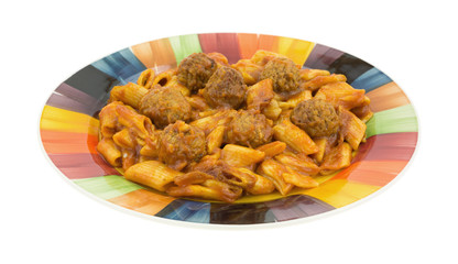Meal of pasta with meatballs on a colorful plate