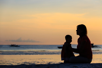 mother and little daughter on sunset beach