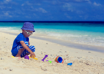 child building sandcastle on the beach