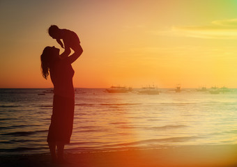 mother and daughter having fun at sunset beach