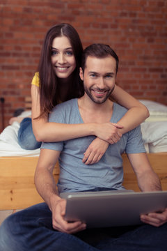 glückliches junges paar mit laptop zu hause