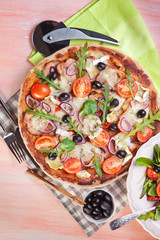Pizza with dry cured ham and salad
