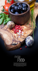 Black olives with bottle of oil on a wooden table
