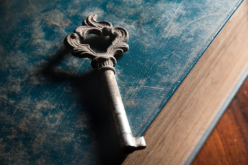 Old metal key on antique book.