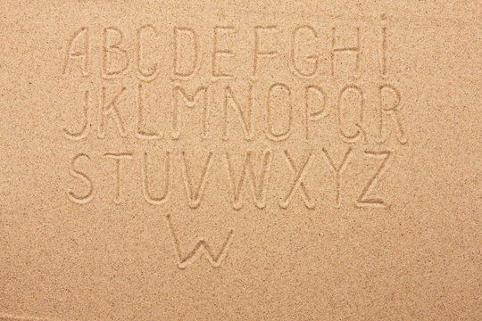 English, German, Portuguese alphabet  written on the sand