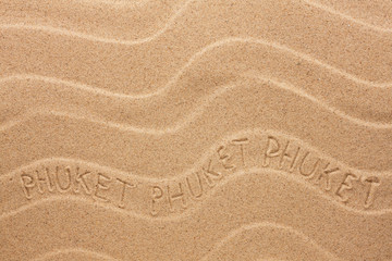 Phuket inscription on the wavy sand